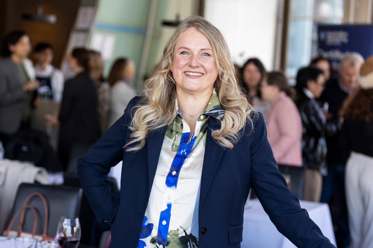Nina Christian smiling at a marketing industry lunch in Sydney, with guests talking behind her
