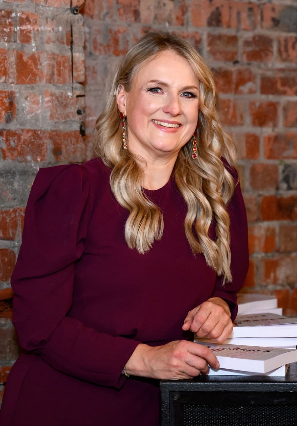 Nina Christian at a table with her book