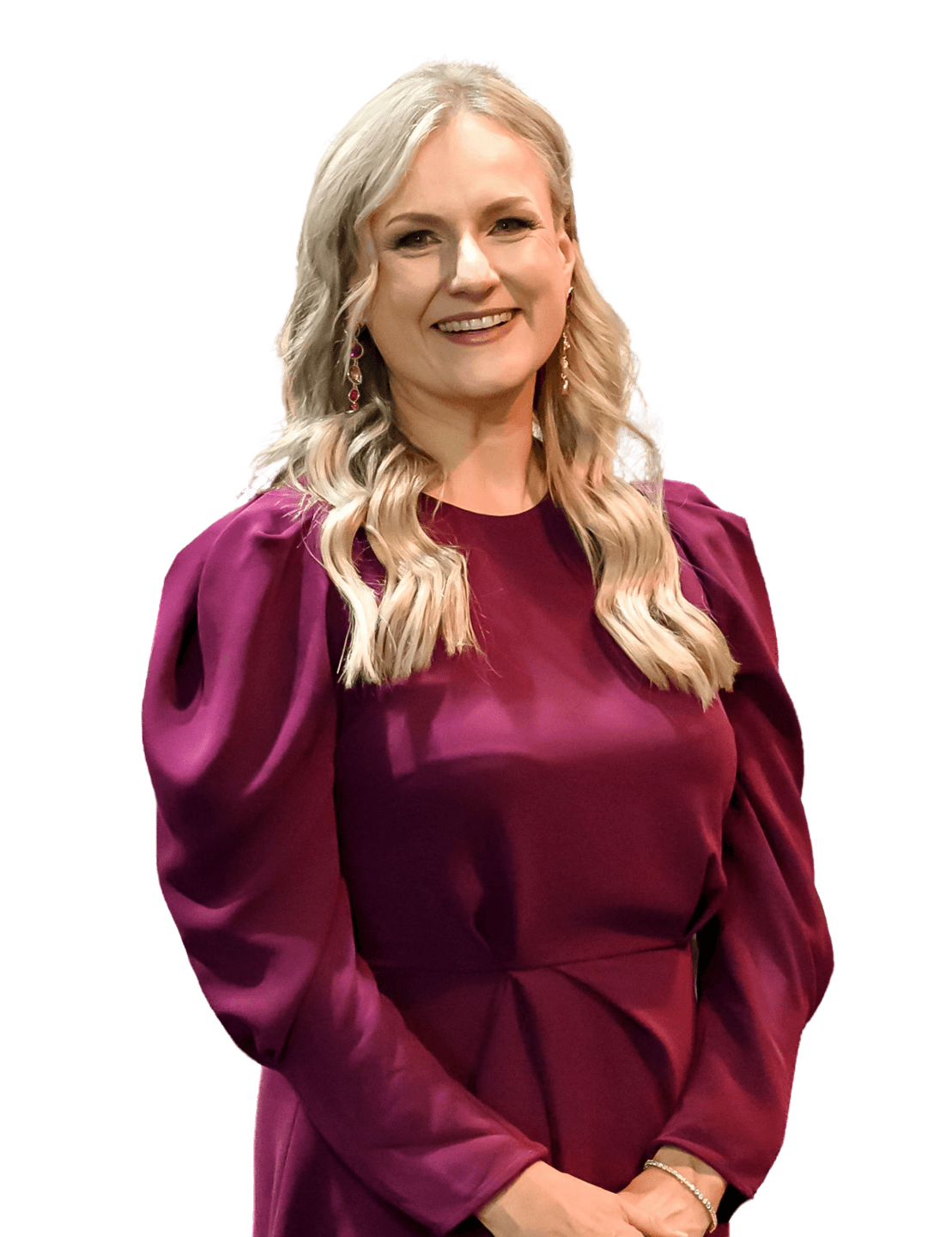 Nina Christian in a burgundy dress in front of colourful feathers