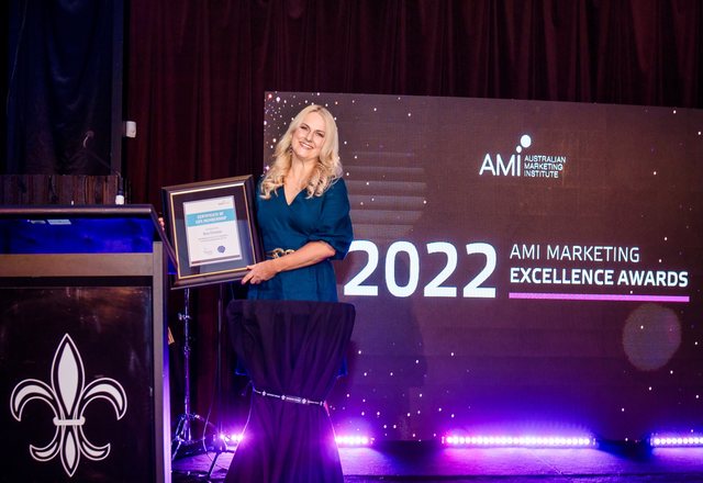 Nina Christian on stage with her Australian Marketing Institute Life Member certificate at the 2022 AMI Marketing Excellence Awards